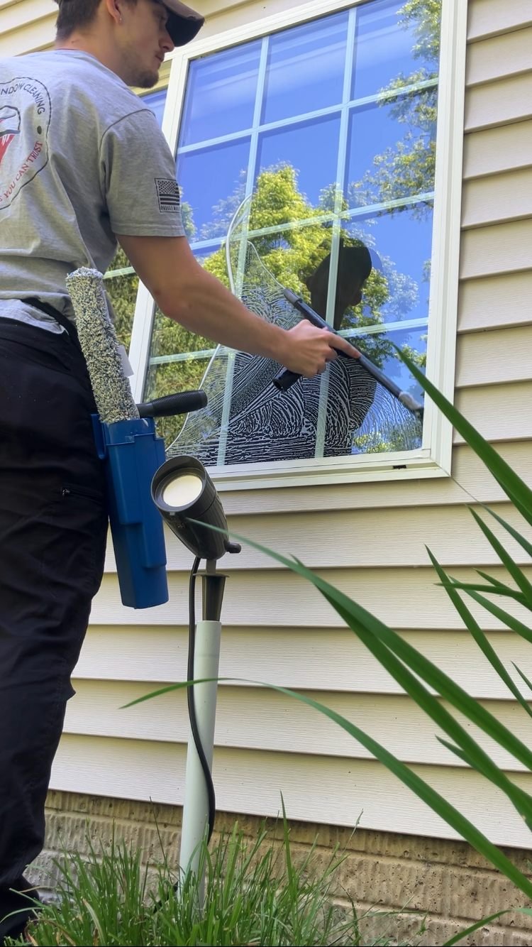 Zane Stacy cleaning a home window